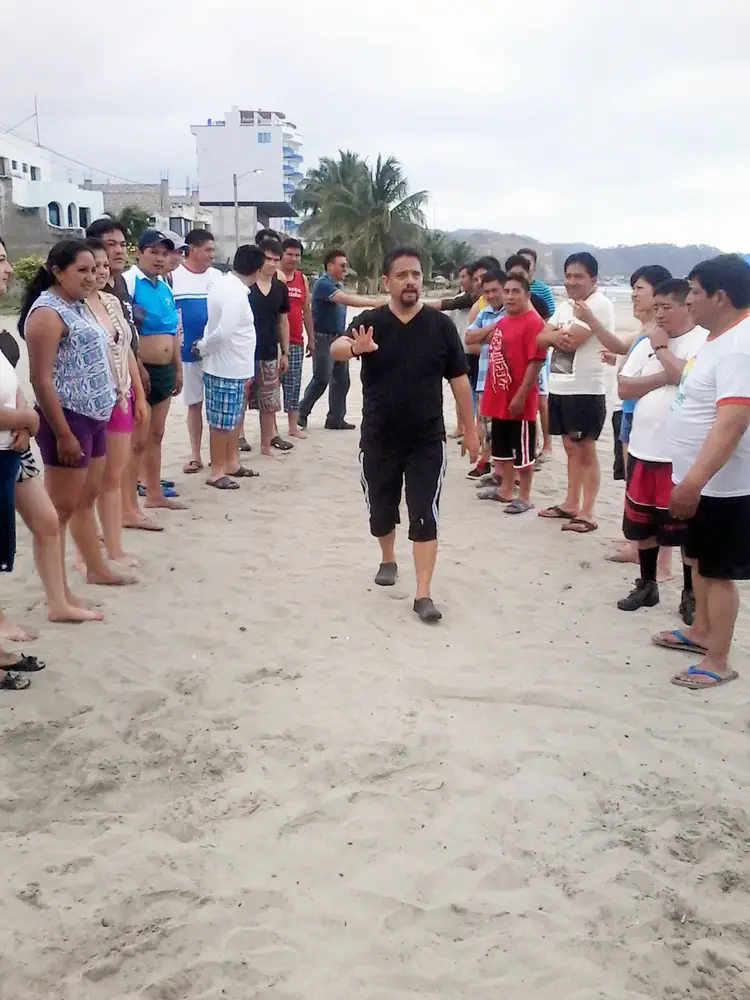 Facilitador guiando una dinámica en la playa